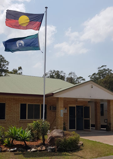 Image of Koobara Aboriginal and Islander Kindergarten and Pre-Prepbuildings and flags in the foreground